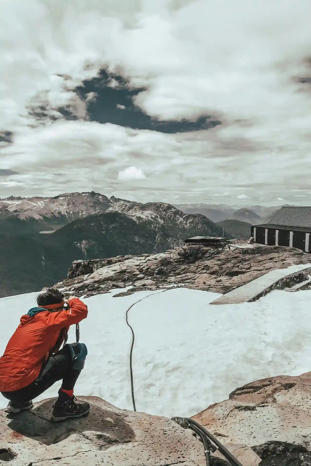 Hiker taking a photo near Refugio Otto Meiling on Mount Tronador, Bariloche, Argentina.