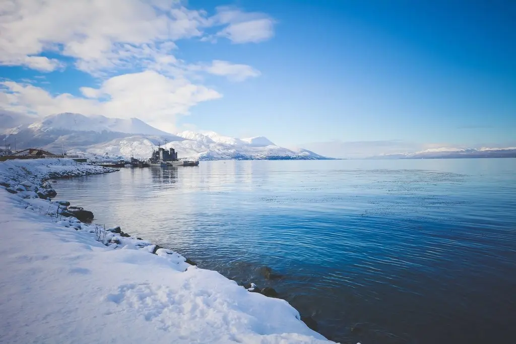 Snow-covered coastline and mountains in Ushuaia overlooking the Beagle Channel during winter.